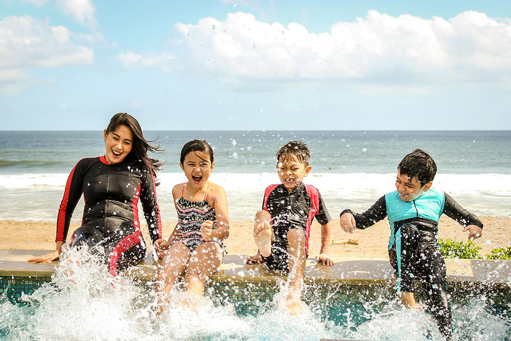 children splashing water at the beach